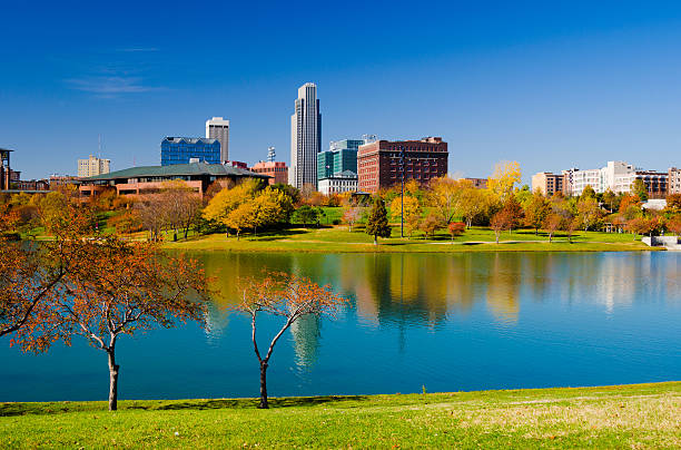Omaha skyline and Heartland of America Park Downtown Omaha skyline with the Heartland of America Park (with a lake and fall colored trees) in the foreground. nebraska stock pictures, royalty-free photos & images