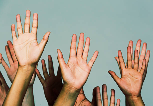 istock Many raised hands against gray: volunteering asking, or responding 452800619