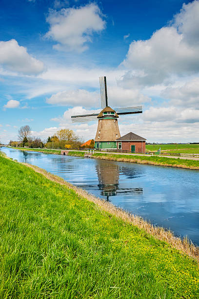 moinho de vento holandeses tradicionais em um típico canal na holanda - polder windmill space landscape - fotografias e filmes do acervo