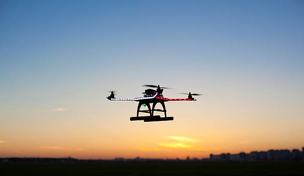 Modern quadrocopter with sunset sky on background stock photo