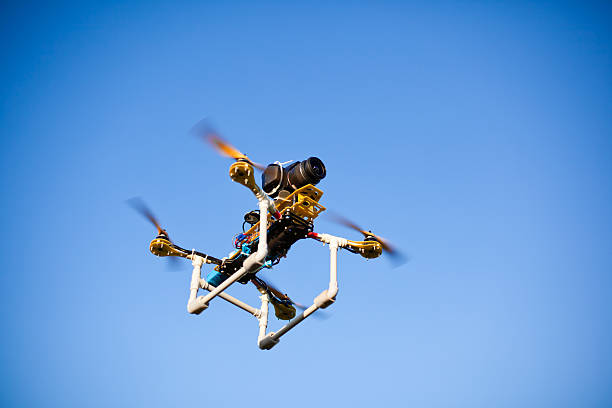 Surveillance drone with camera on blue background stock photo