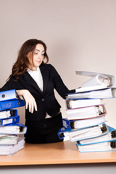 istock Frustrated businesswoman with stack of folders at office 452966787