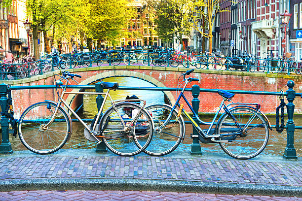 Typical Amsterdam City Scene. Visible are one of the many beautiful bridges, bikes, and traditional dutch houses. Amsterdam, Netherlands.