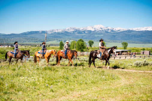 Young Family of four vacationing on horse back at Dude Ranch