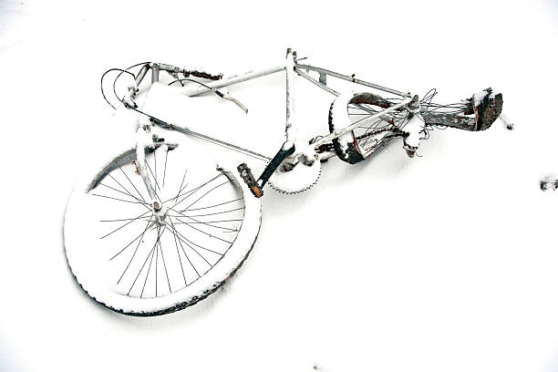 damaged old bycicle in wintertime covered by snow