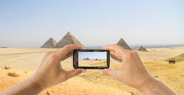 turista tiene telecamera a un cellulare alle piramidi - kephren foto e immagini stock