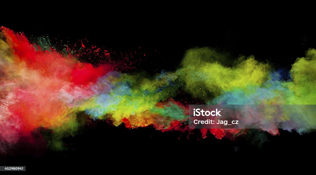 Multi-colored paint dust spread across a black background Freeze motion of colored dust explosion isolated on black background Abstract Stock Photo