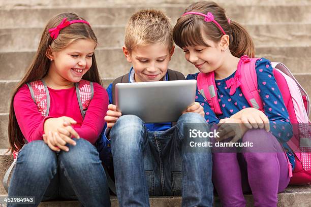 School Children Using Digital Tablet Outside Stock Photo - Download Image Now - 8-9 Years, Back to School, Backpack