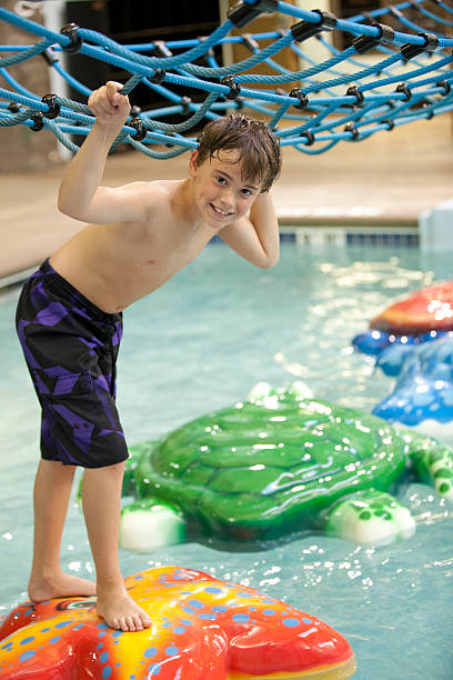 istock Young boy playing at the indoor water park 452986081