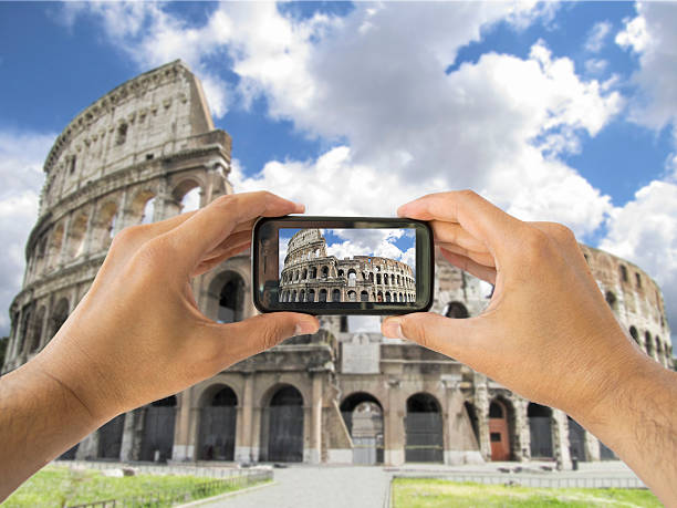 istock tourist holds up camera mobile at coliseum in Rome 452990427