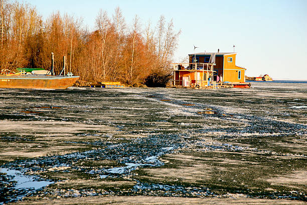 Spring Breakup, Yellowknife, Northwest Territories The ice is breaking up and water is showing with houseboats just off Jollife Island, Yellowknife, Northwest Teritories, Canada. People live on these boats all year round. They use solar power. great slave lake stock pictures, royalty-free photos & images