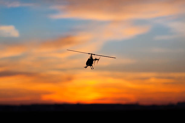 An Ecureuil H125A helicopter hovering over a runway in rural Switzerland