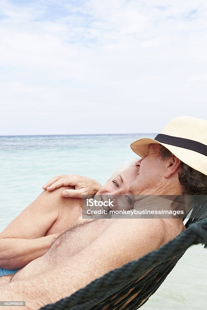 Couple âgé se détendre dans le hamac sur la plage - Photo de Affectueux libre de droits