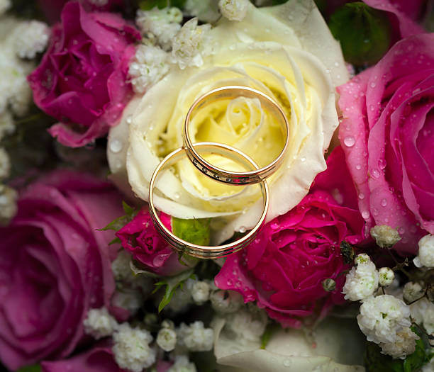 istock wedding rings  groom and  bride on a bunch of flow 452999995