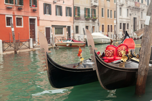 Two gondola in Venice near pier in channel
