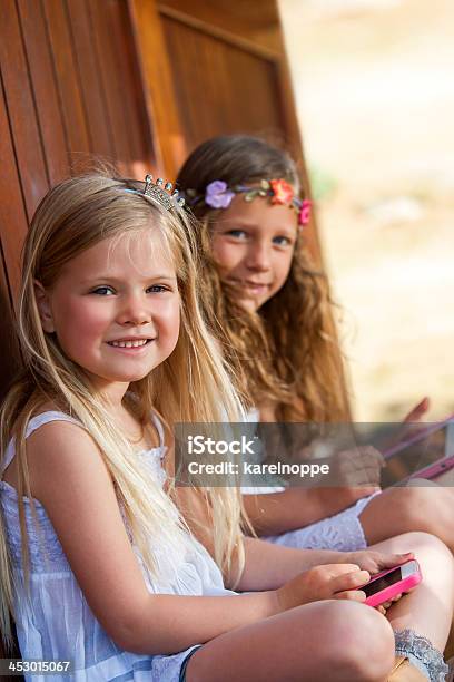 Two Girls Playing With Digital Devices Stock Photo - Download Image Now - Activity, Beautiful People, Beauty