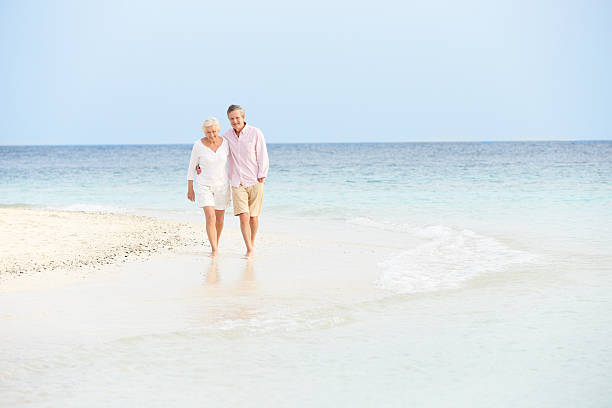istock A senior couple walking on a beach 453017387