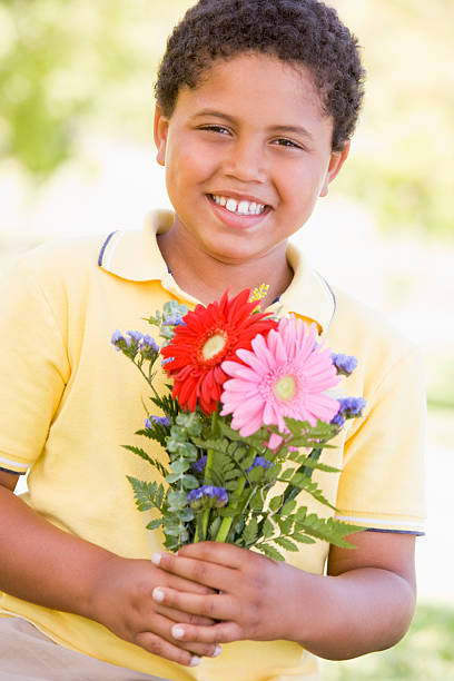 istock Young boy holding flowers and smiling 453020271