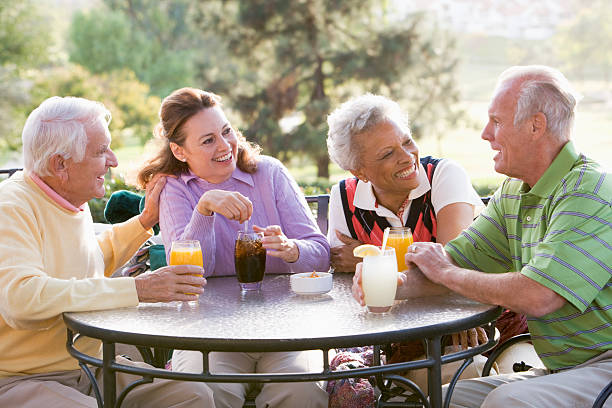 Friends Enjoying  Beverage By A Golf Course Friends Enjoying A Beverage By A Golf Course Sitting Down At Table Chatting country club stock pictures, royalty-free photos & images