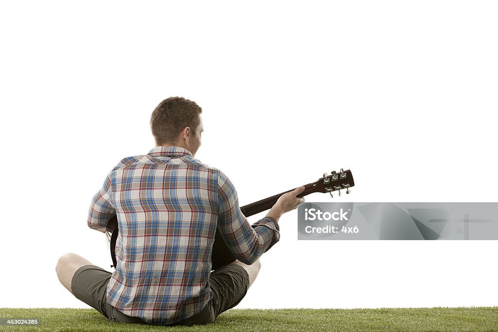 Mann spielt Gitarre auf dem Rasen - Lizenzfrei Straßenmusiker Stock-Foto