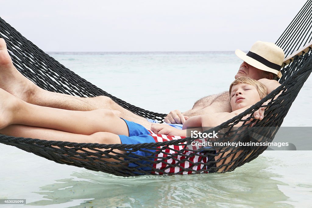 Grand-père et son petit-fils se détendre dans un hamac sur la plage - Photo de Grand-parent libre de droits