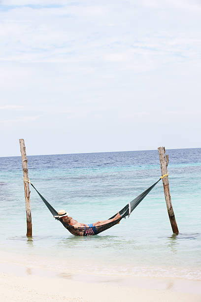 istock Grandfather And Grandson Relaxing In Beach Hammock 453025277