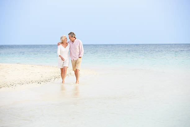 istock Romantic Senior Couple Walking On Beautiful Tropical Beach 453025417