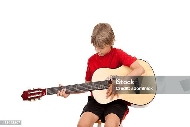 Young Boy Aprender A Jugar Guitarra Acústica Foto de stock y más banco de imágenes de 8-9 años - 8-9 años, Agarrar, Aprender