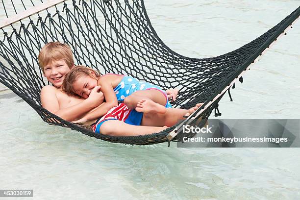 Fratello E Sorella Rilassarsi In Spiaggia Sullamaca - Fotografie stock e altre immagini di Affettuoso