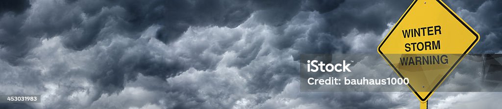 Winter Storm Road Sign A Caution Sign in front of storm clouds warning of a "Winter Storm." Backgrounds Stock Photo