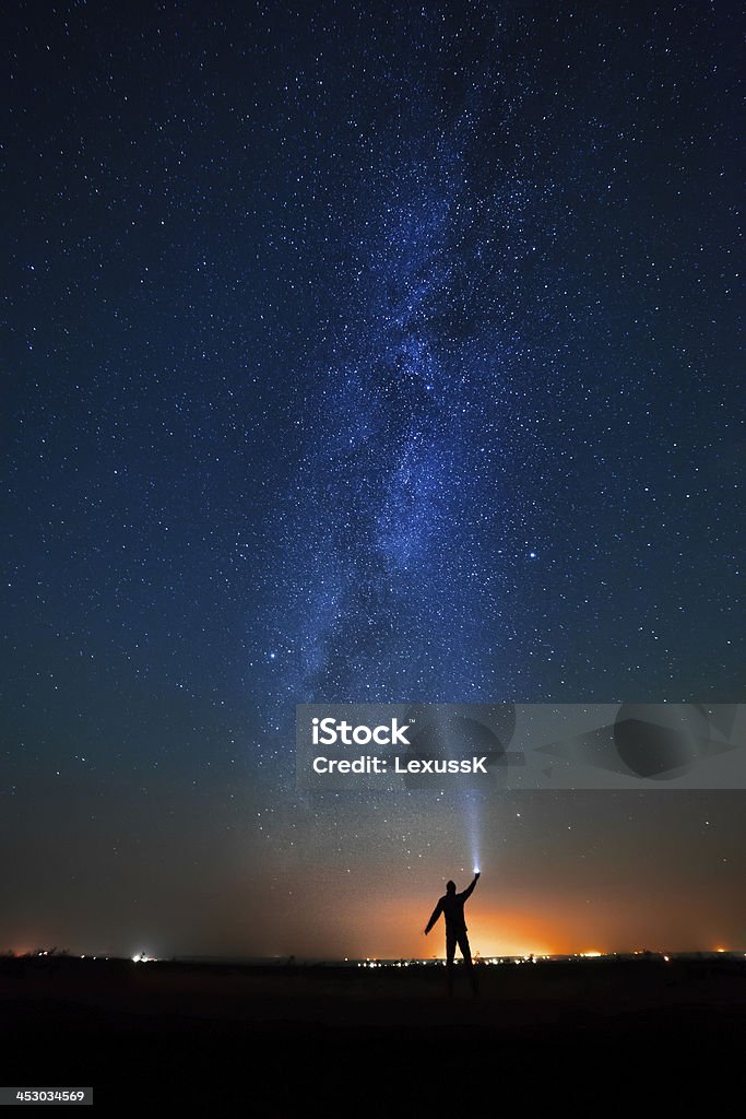 Homem no fundo de estrelas brilhantes céu noturno. - Foto de stock de Astronomia royalty-free