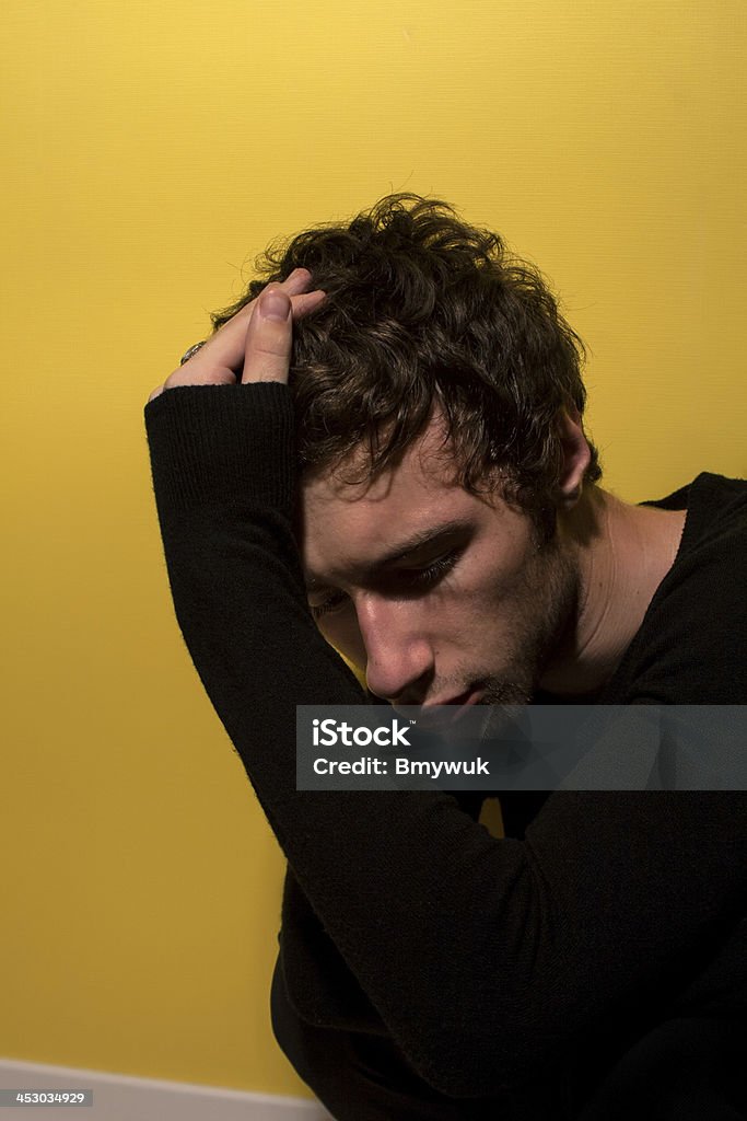Depressed man Depressed man embracing his head Blackout Stock Photo
