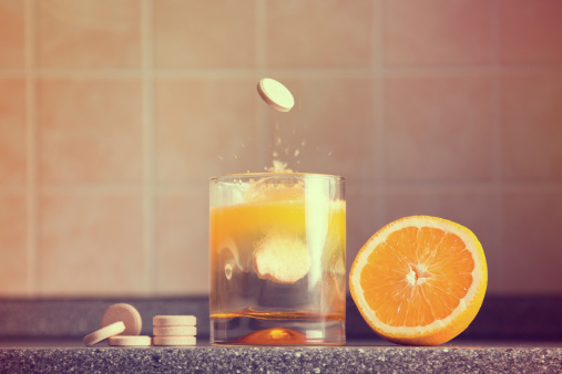 Artistic shot of vitamin C family, orange, tablet stack, dissolving tablet