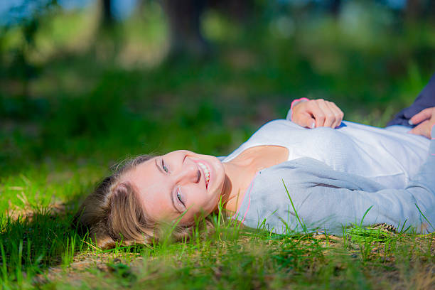 istock Smiling woman lying on grass 453037857