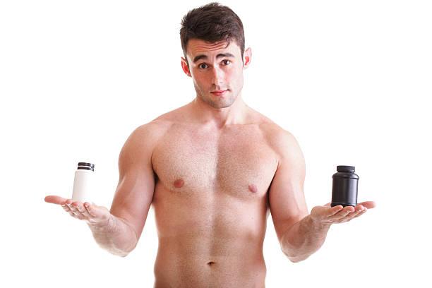 , держащий коробки с добавок на его бицепсы - creatine nutritional supplement men human muscle стоковые фото и изображения