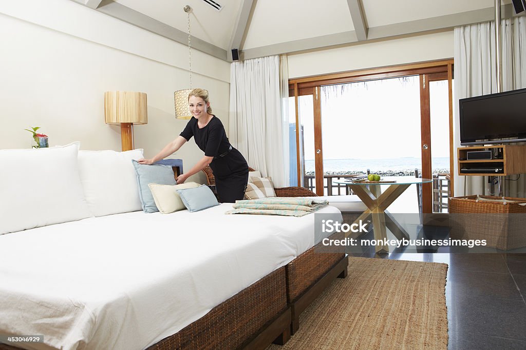 Hotel Chambermaid Making Guest Bed Hotel Chambermaid Making Guest Bed Looking To Camera Smiling Bed - Furniture Stock Photo
