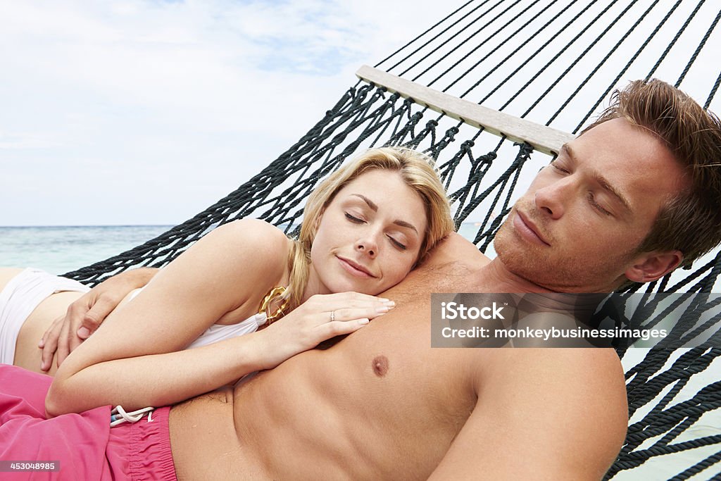 Couple de détente dans le hamac sur la plage - Photo de Affectueux libre de droits