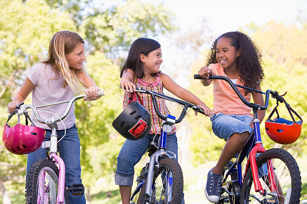 istock Three young girl friends outdoors on bicycles smiling 453049753