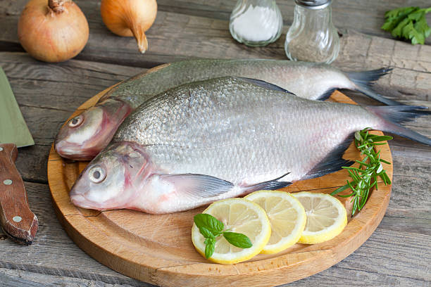 istock Bream raw fish on cutting board in the kitchen 453054937