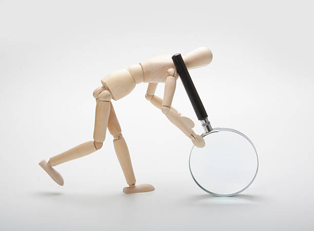 istock Wooden man with magnifying glass 453062403