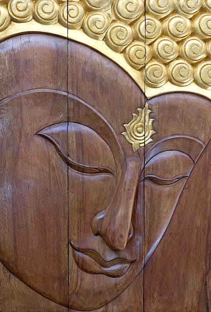 istock buddha face wood carving 453068107