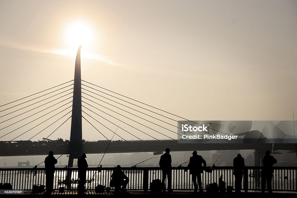 people fishing on Galata Bridge Silhouettes of people fishing on Galata Bridge, Istanbul, with new swing bridge over the Golden Horn in background Bridge - Built Structure Stock Photo