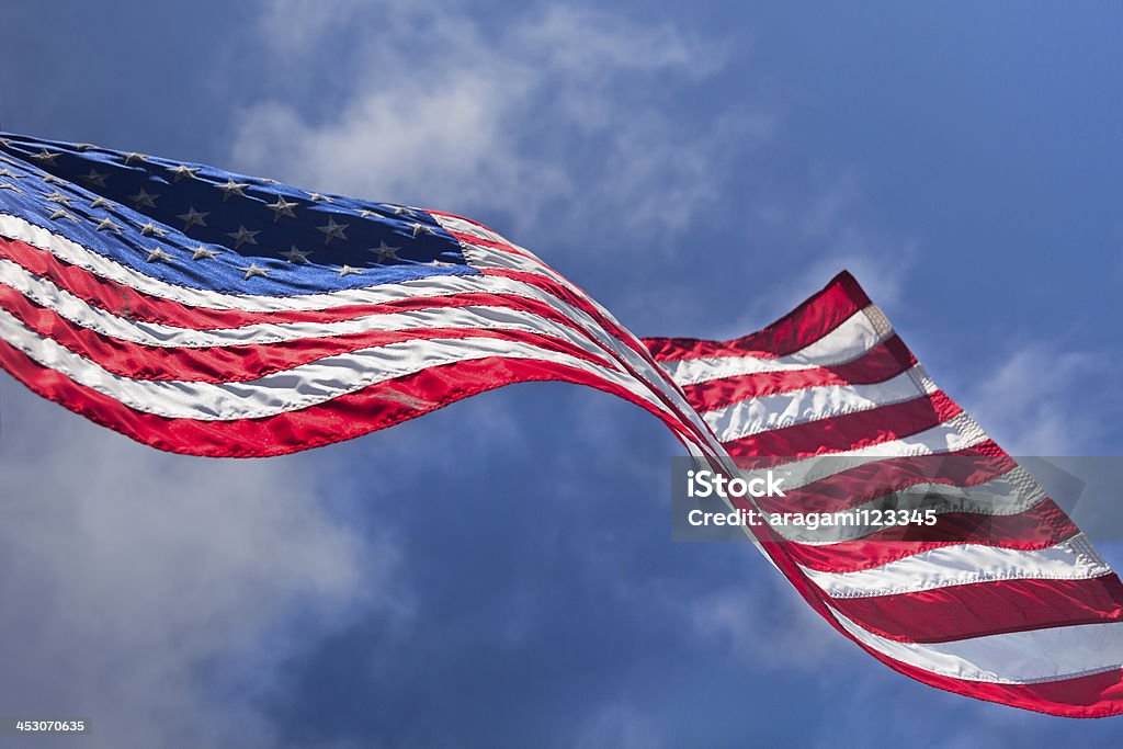 USA flag waving on the wind USA flag waving on the wind on cloudy sky background American Flag Stock Photo