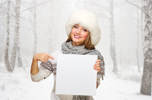 istock Girl with blank poster at snowy forest 453072481