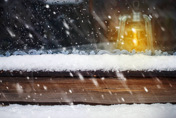 オイルランプには、木製のウィンドウと落ちる雪 - old plank outdoors selective focus ストックフォトと画像