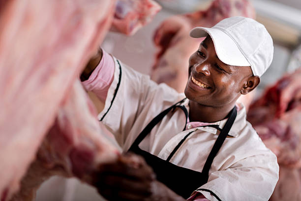 Butcher preparing the meat Happy man working as butcher and preparing the meat meat locker photos stock pictures, royalty-free photos & images