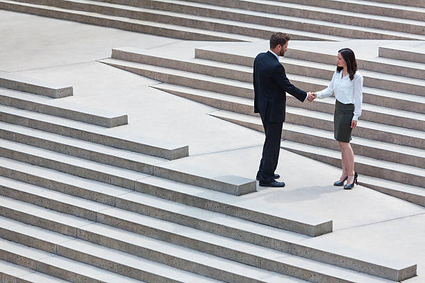 istock A man in suits shaking hands with a professional lady 453080245