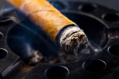 lit cigar and black ashtray