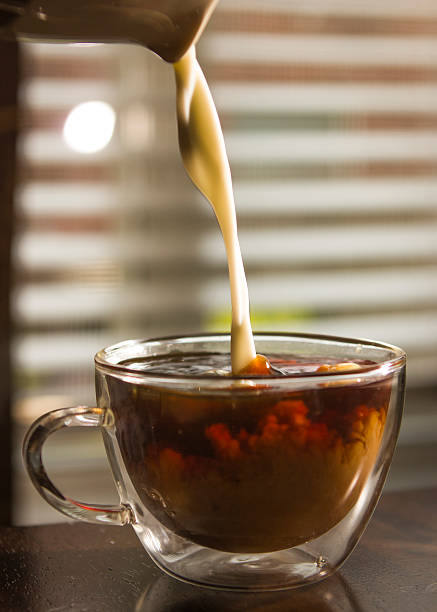 istock Creamer poured from container into a glass mug of coffee 453084351