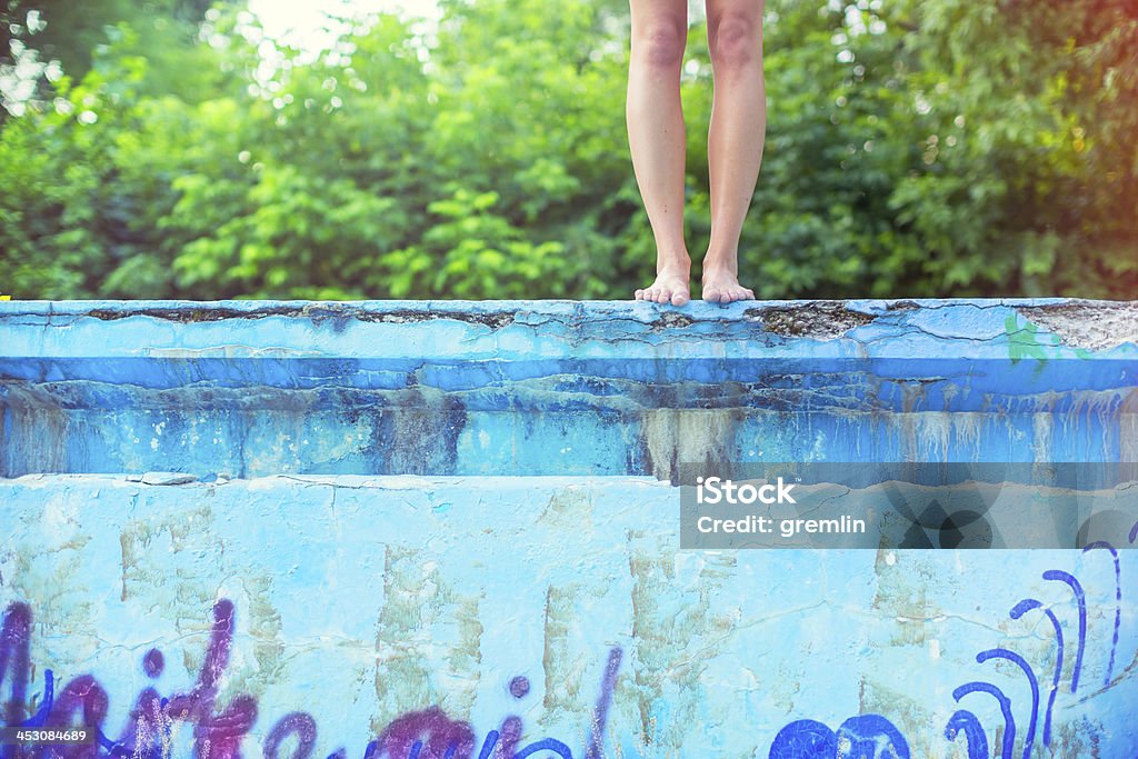 Jeune femme sur le point de piquer une tête dans la piscine vide - Photo de Piscine libre de droits